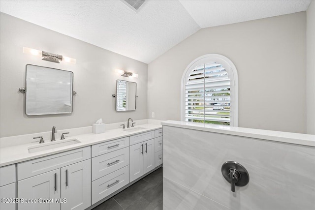 bathroom with vanity, tile patterned floors, a textured ceiling, and lofted ceiling