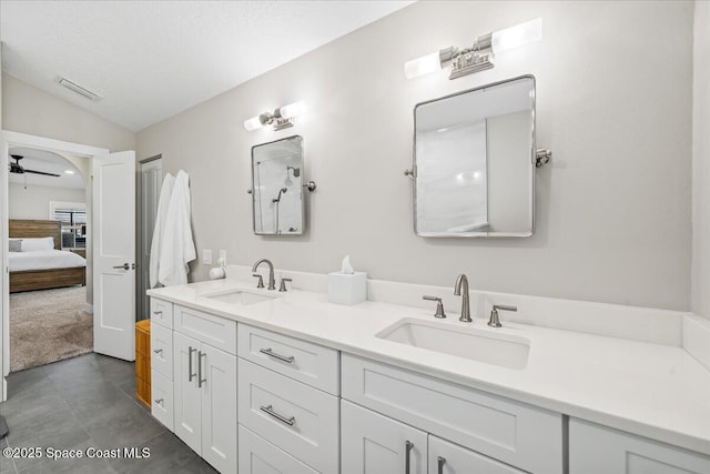 bathroom with vanity, ceiling fan, a textured ceiling, and lofted ceiling