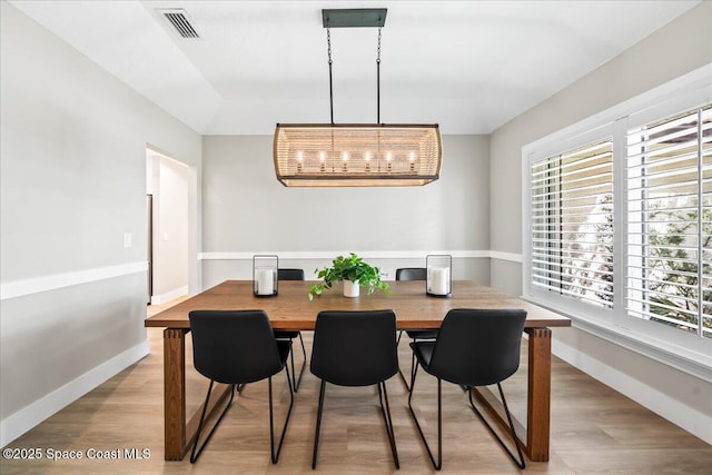 dining room featuring light hardwood / wood-style floors and a chandelier