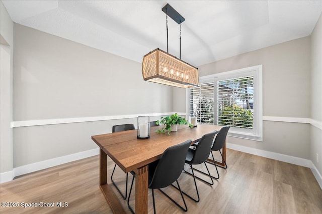 dining room featuring light wood-type flooring and a notable chandelier