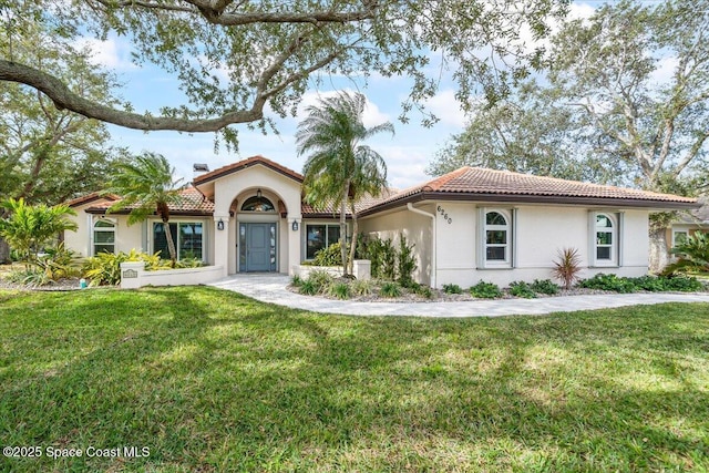 mediterranean / spanish home featuring a front yard