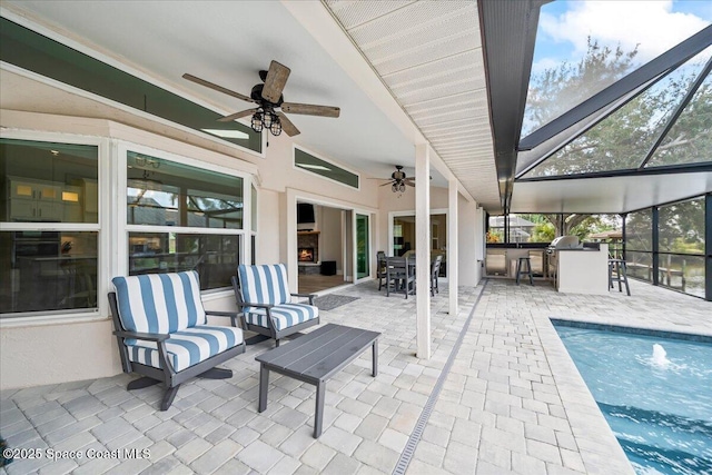 view of patio with ceiling fan, exterior bar, and glass enclosure