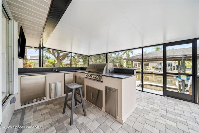 sunroom / solarium featuring sink and a water view