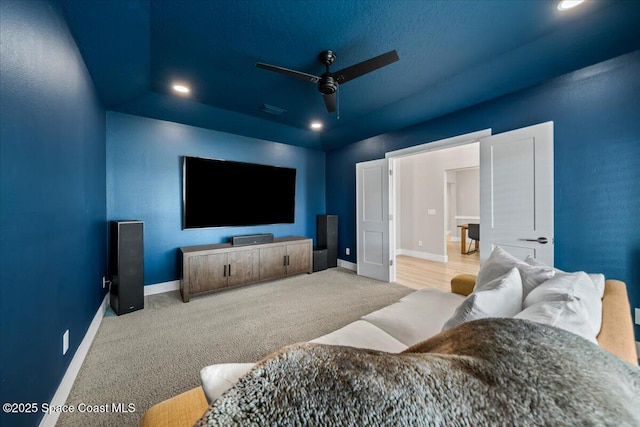 home theater with ceiling fan and light colored carpet