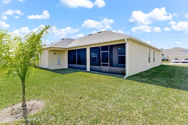 back of property with a sunroom and a lawn