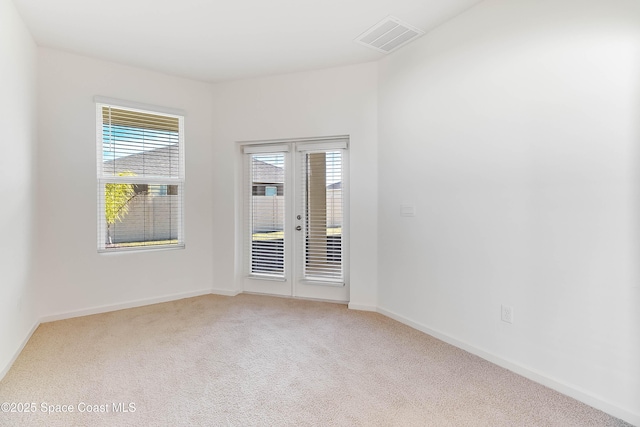 carpeted spare room with french doors