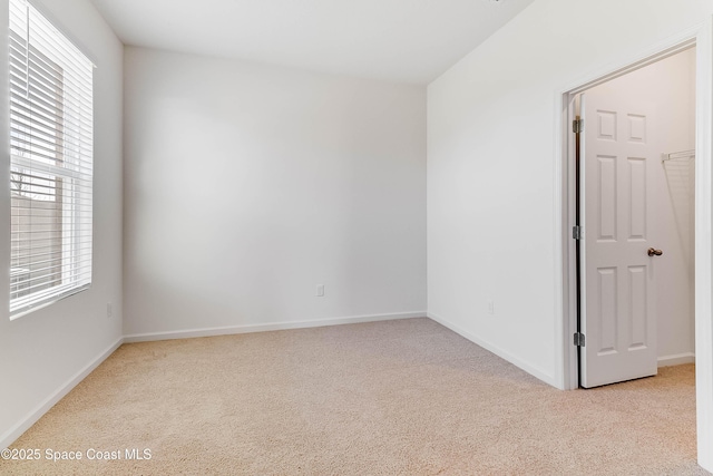 unfurnished room featuring light carpet