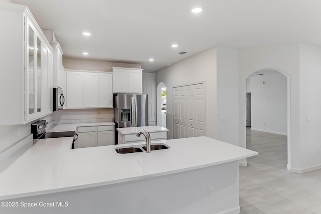 kitchen featuring kitchen peninsula, white cabinetry, sink, and stainless steel appliances