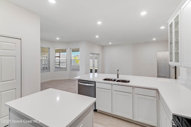 kitchen with white cabinets, a center island with sink, dishwasher, and sink