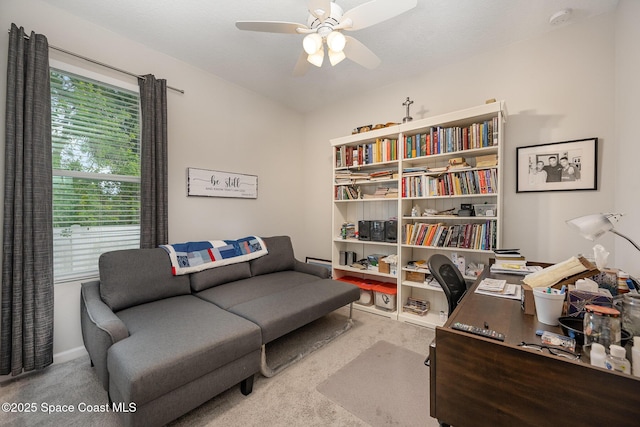 home office featuring a wealth of natural light, ceiling fan, and light carpet