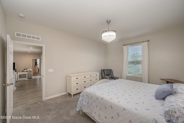 carpeted bedroom with a chandelier