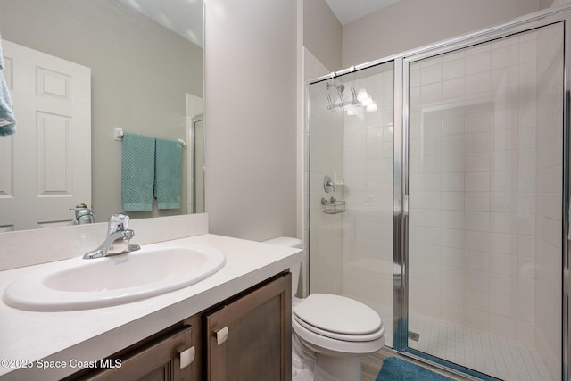 bathroom featuring toilet, walk in shower, and vanity