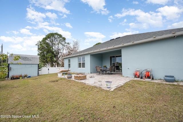 back of property with a lawn, a storage unit, and a patio