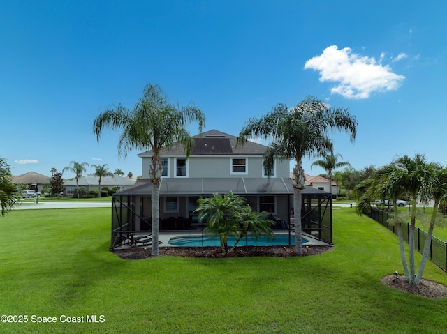 rear view of house featuring a lawn, glass enclosure, and a fenced in pool