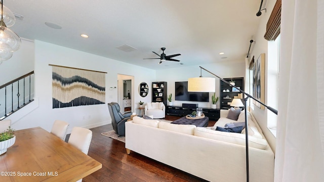 living room with ceiling fan and dark wood-type flooring