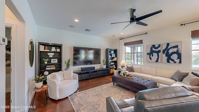 living room with ceiling fan and dark hardwood / wood-style flooring