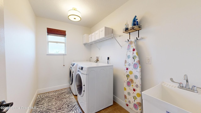 laundry area featuring sink, light tile patterned flooring, and independent washer and dryer