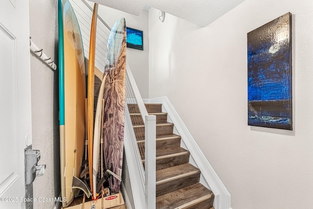 staircase with a textured ceiling