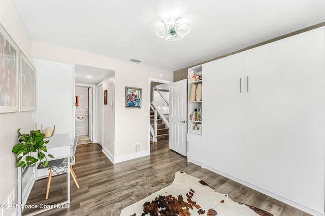 interior space featuring a textured ceiling and dark hardwood / wood-style floors