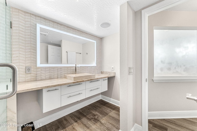 bathroom with vanity, hardwood / wood-style floors, a textured ceiling, and an enclosed shower