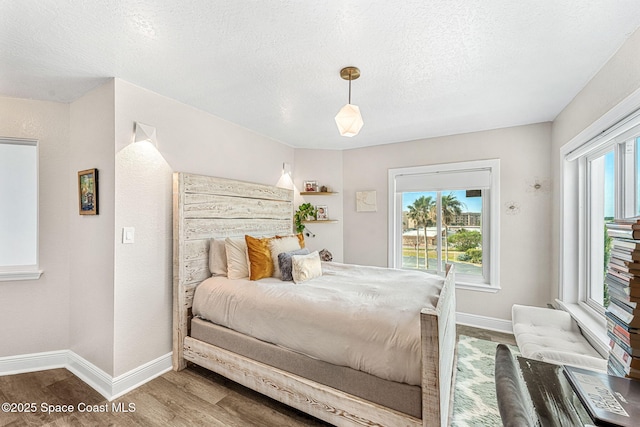 bedroom with wood-type flooring and a textured ceiling