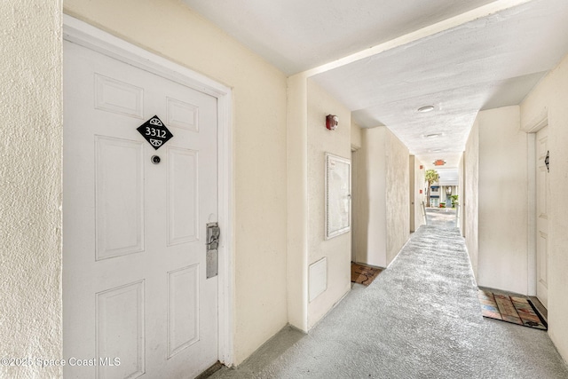 hallway with carpet floors and a textured ceiling