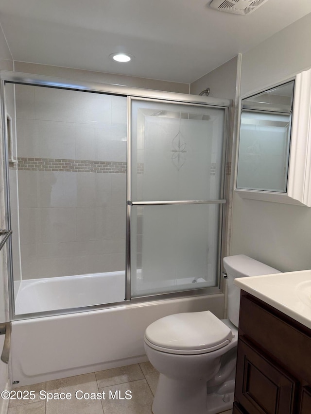 full bathroom featuring toilet, vanity, tile patterned flooring, and combined bath / shower with glass door