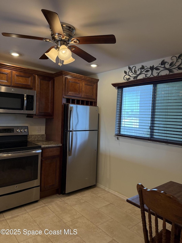 kitchen with light tile patterned floors, ceiling fan, and appliances with stainless steel finishes