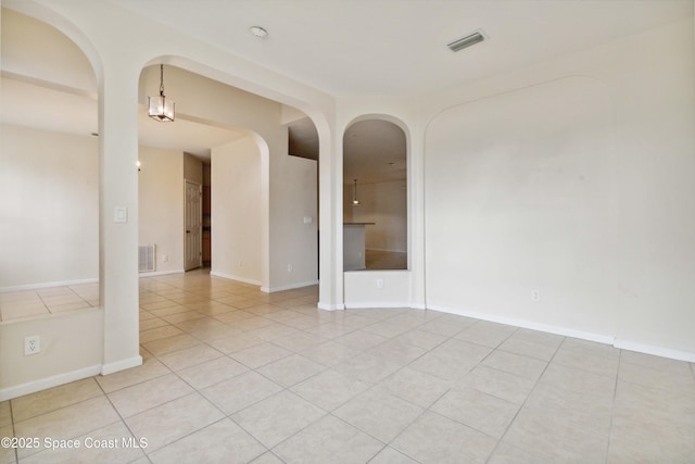 unfurnished room featuring light tile patterned floors and a chandelier