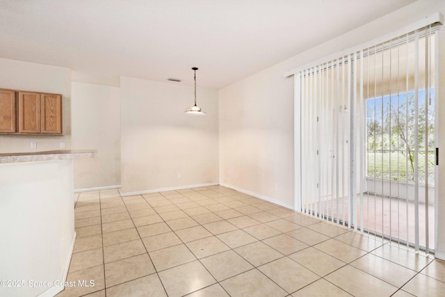 unfurnished dining area featuring light tile patterned flooring