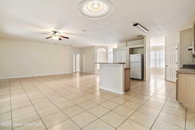 kitchen with ceiling fan, light tile patterned floors, and white fridge