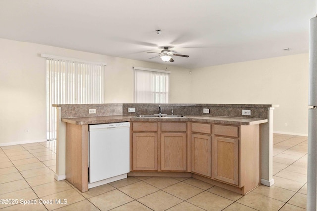 kitchen featuring light tile patterned floors, white dishwasher, and a center island with sink