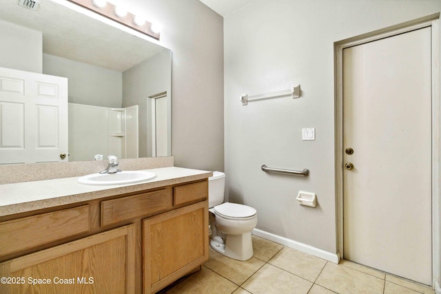 bathroom with toilet, vanity, walk in shower, and tile patterned flooring