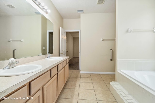 bathroom featuring a relaxing tiled tub, vanity, and tile patterned flooring