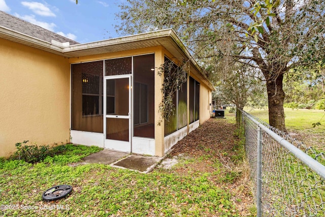 view of side of property with a sunroom and central air condition unit