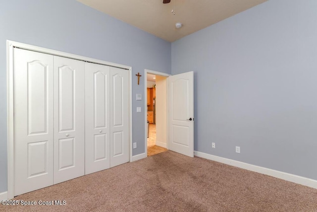 unfurnished bedroom featuring ceiling fan, a closet, and carpet flooring