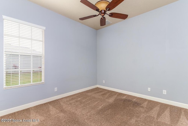 empty room featuring ceiling fan and carpet