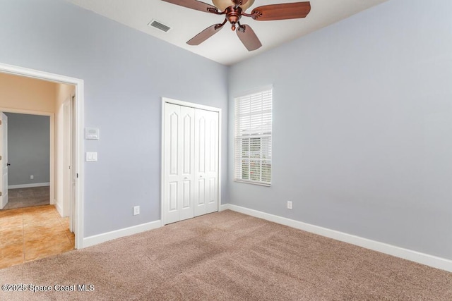 unfurnished bedroom with ceiling fan, light colored carpet, and a closet