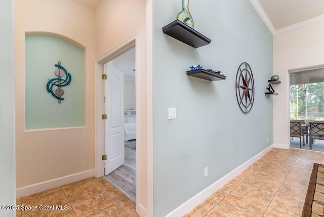 hallway featuring ornamental molding and light tile patterned flooring