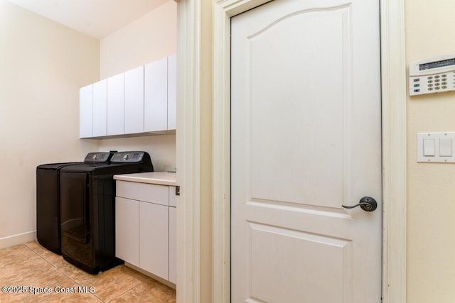 washroom with washer and clothes dryer, light tile patterned floors, and cabinets