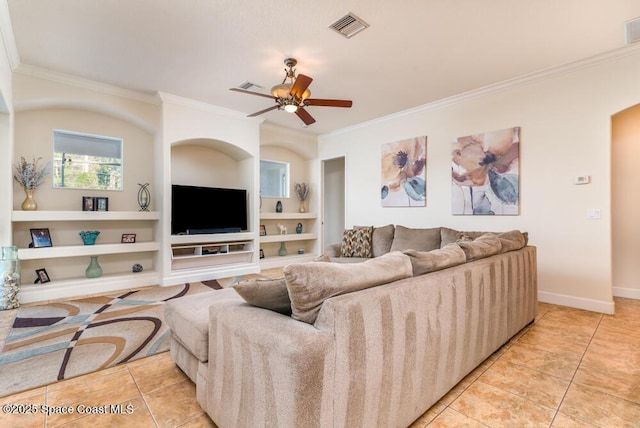 tiled living room with ceiling fan, crown molding, and built in shelves