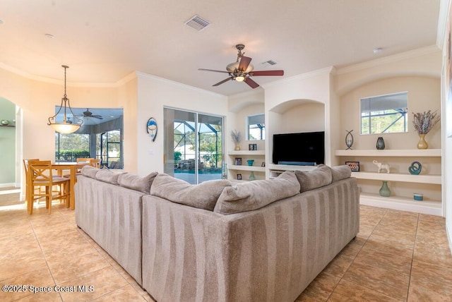 living room with ceiling fan, built in shelves, light tile patterned floors, and ornamental molding