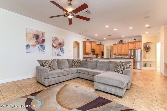 tiled living room with ceiling fan, sink, and ornamental molding