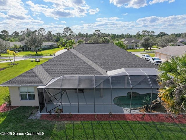 rear view of property featuring a lanai, a lawn, and a patio