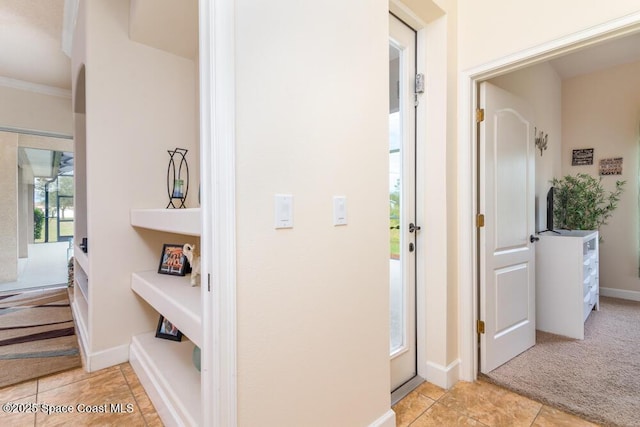 corridor with light carpet and crown molding