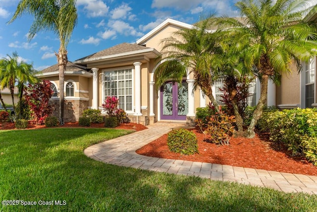 mediterranean / spanish-style home with a front yard and french doors