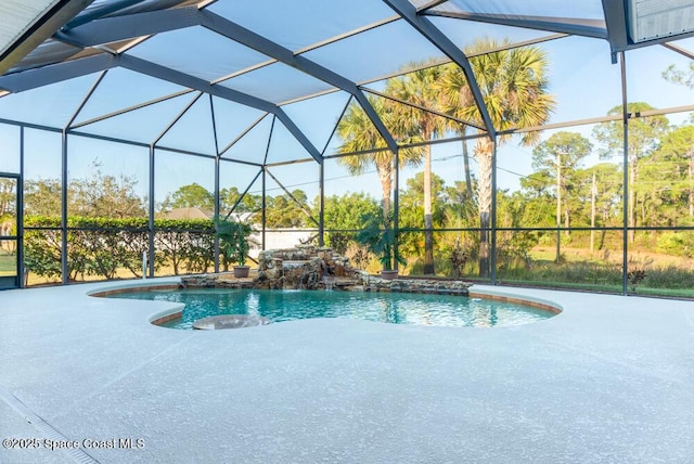 view of swimming pool with pool water feature, glass enclosure, and a patio