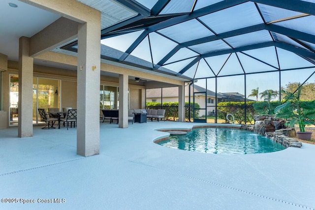 view of pool featuring glass enclosure, outdoor lounge area, a patio, ceiling fan, and pool water feature