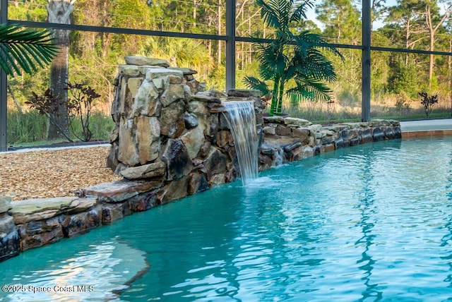 view of pool featuring glass enclosure