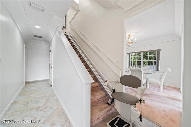 staircase featuring crown molding, carpet flooring, a textured ceiling, and an inviting chandelier